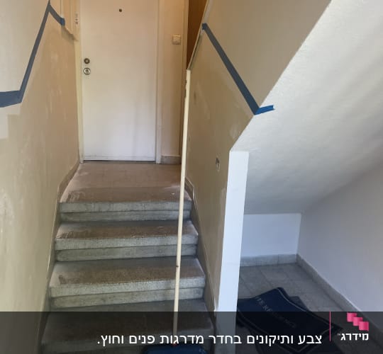 סרט דבק כחול על קירות מדרגות לצביעת קווים ישרים